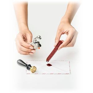 Hands melting sealing wax with the Swingtop Lighter beside a wax stamp - The Simple Man