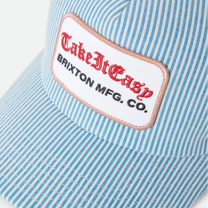 Brixton Take It Easy trucker hat patch close-up — merrowed edge embroidered patch with red old English script on blue white stripe