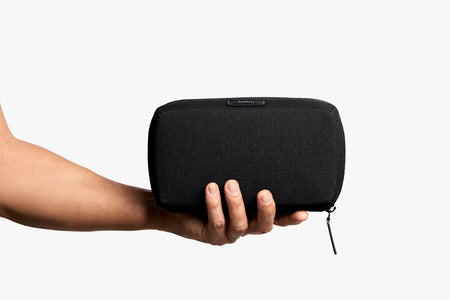 Bellroy Tech Kit in Black, closed position shown in human hand for size comparison