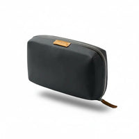 Slate tech kit with a brown zipper pull on a light gray background