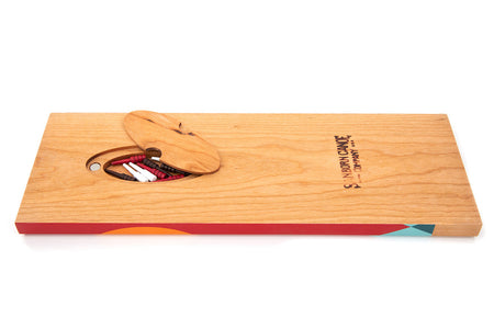 Rear storage compartment with magnetic lid on cherry wood Tettegouche cribbage board holding red, white, and dark pegs