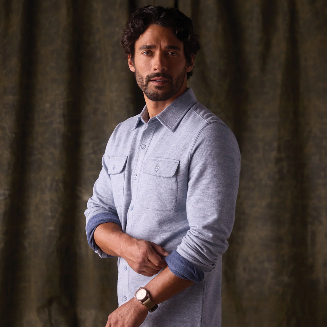 Man wearing Textured Knit Shirt in Vintage Blue, angled standing view showing chest pockets and cuffs