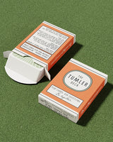 Tumler Deck conversation playing cards in orange box on green surface