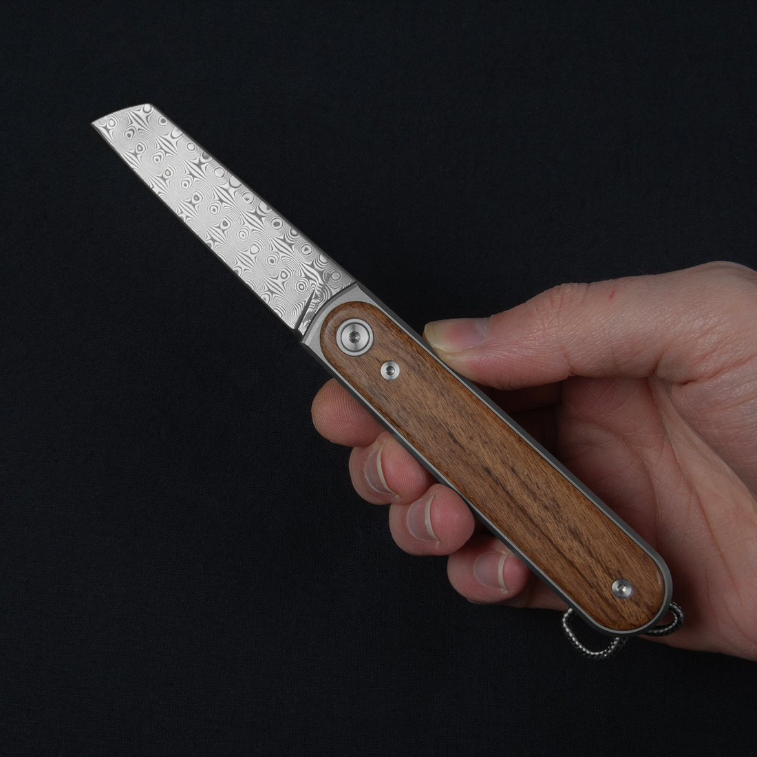 Duval Damasteel pocket knife held open in one hand to show its slim size