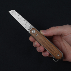 Duval Damasteel pocket knife held open in one hand to show its slim size