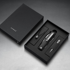 Helton in Black + Stainless in its box with lanyard and bead, top-down view