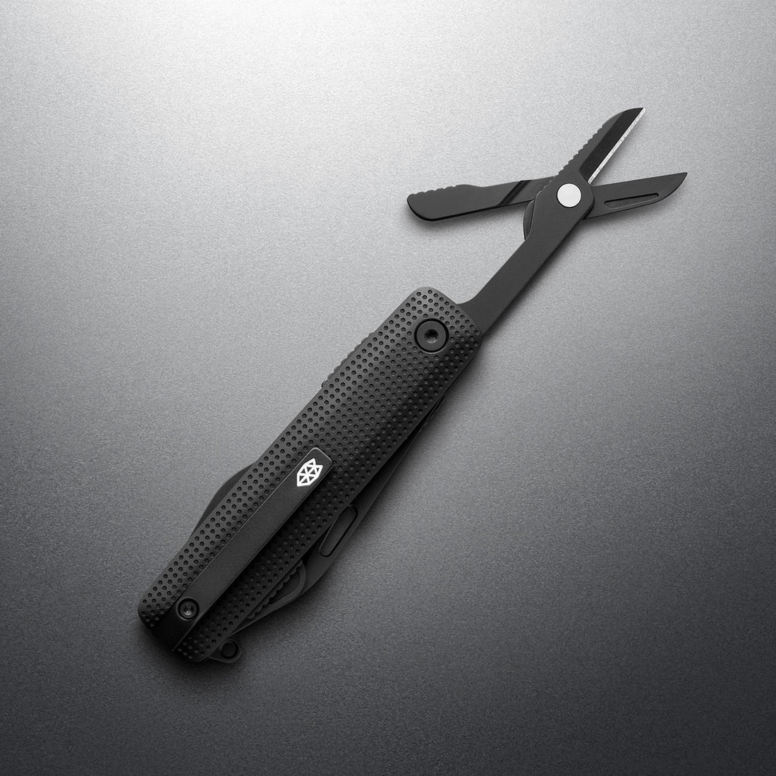 Black + Black Helton with spring-action scissors open, angled view