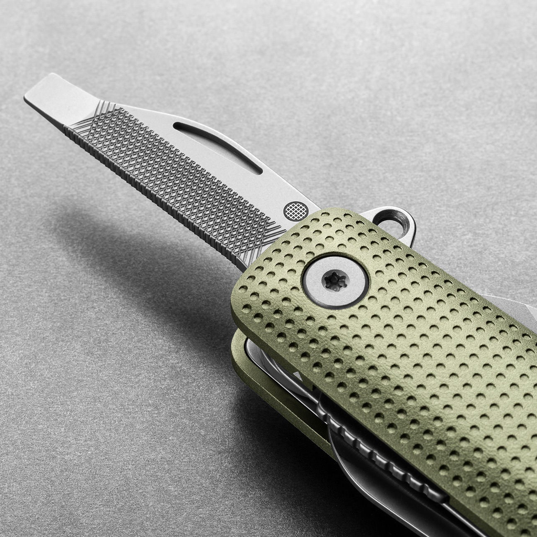 Helton in Grove + Stainless with flathead driver and file tool extended, detail view