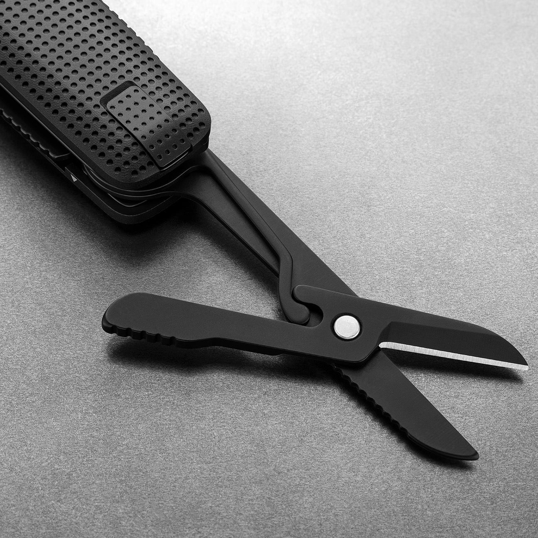 Spring-action scissors open on the Helton in Black + Black, close-up