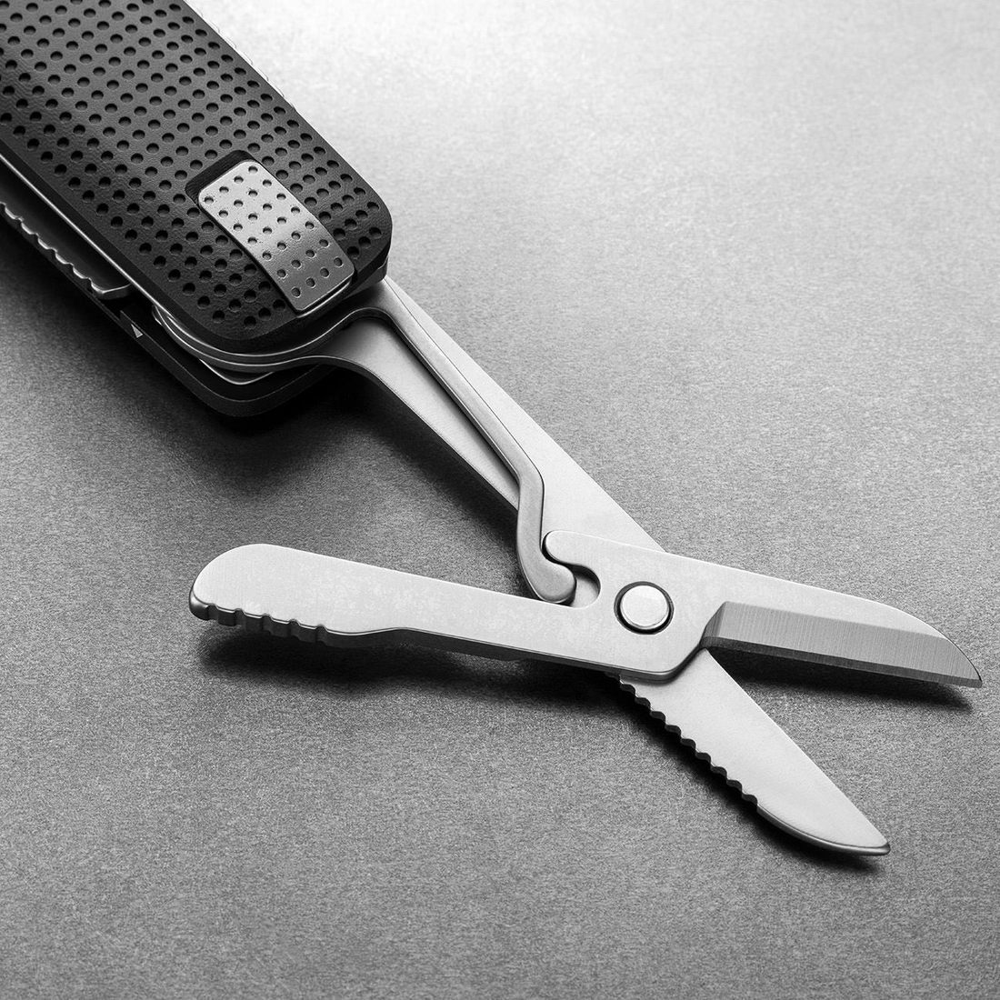 Spring-action scissors open on the Helton in Black + Stainless, close-up