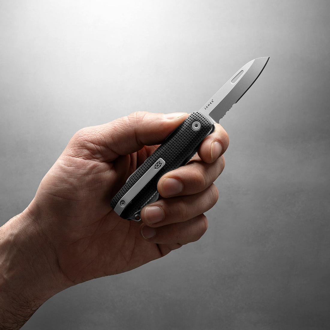 Hand holding the Helton multitool with the blade open