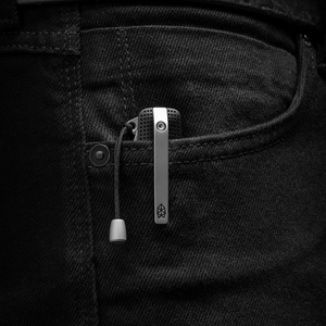 Helton multitool clipped in a jeans pocket with the lanyard bead hanging out