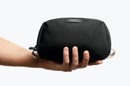Bellroy Toiletry Kit in black, closed view in models hand for size comparison