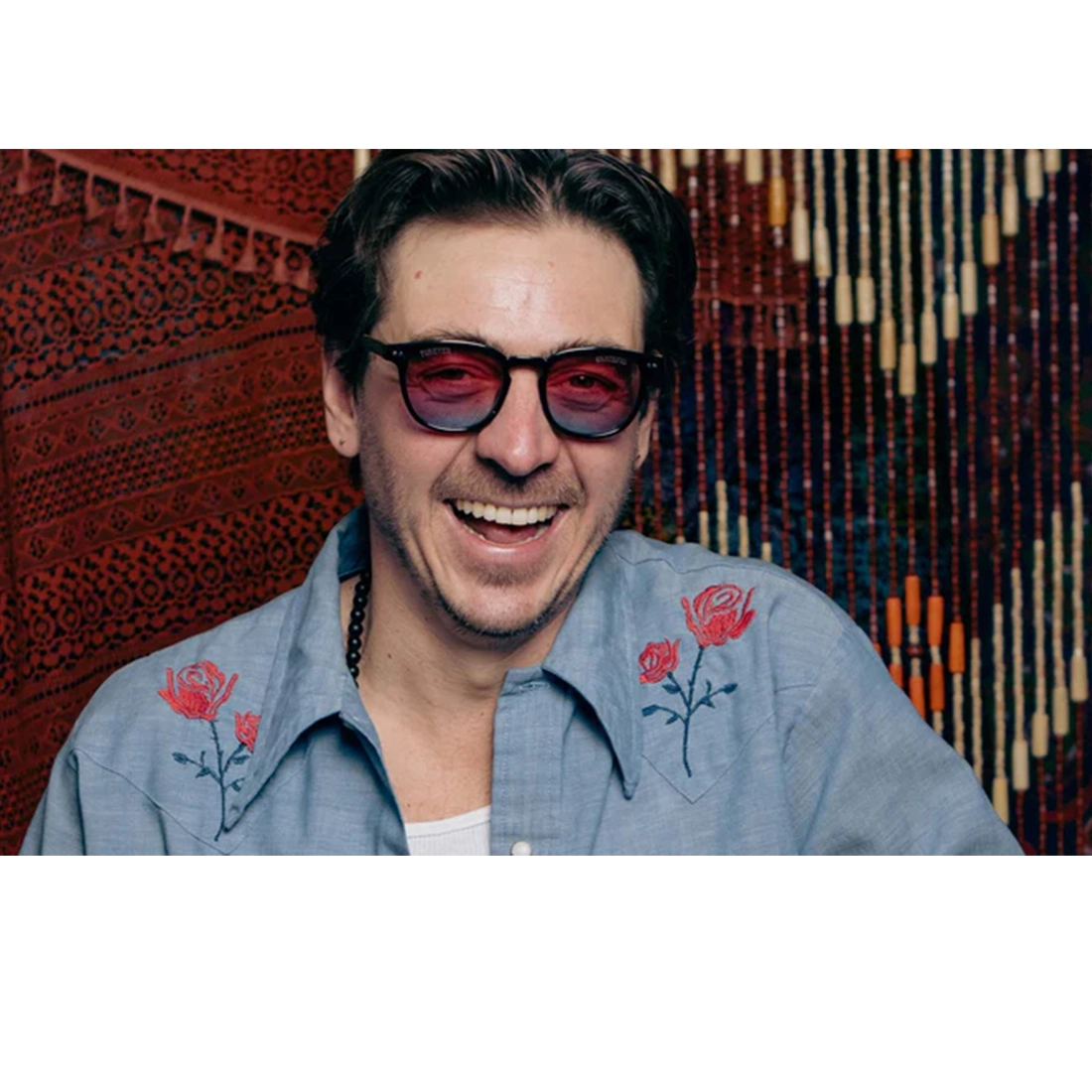 Man wearing Grateful Dead Stealie polarized sunglasses black frame with red blue gradient lenses