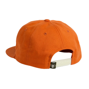 Back view of the Silver King Unstructured Snapback Hat in Toasted Orange, showing adjustable strap and monkey patch -- The Simple Man