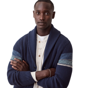 Close view of the navy shawl collar and striped sleeve on the Varsity Cardigan, worn over a henley