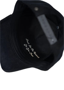 Inside brim of black corduroy hat showing embroidered quote 'Don't let the bastards get you down