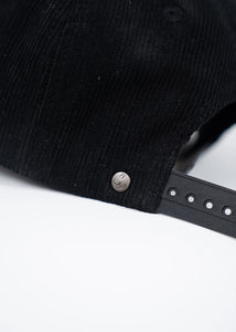 Back view of vintage black corduroy snapback hat with anchor logo stud detail