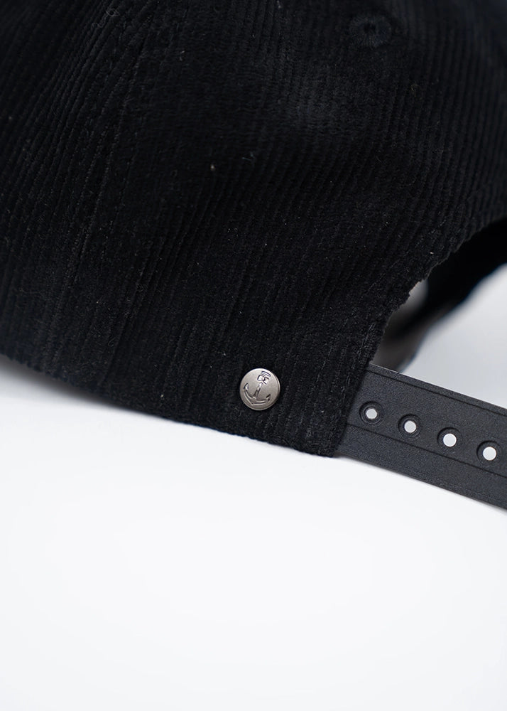 Back view of vintage black corduroy snapback hat with anchor logo stud detail