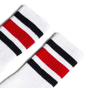 Close up of black and red striped crew socks with cushioned ribbed knit and white body, made in USA