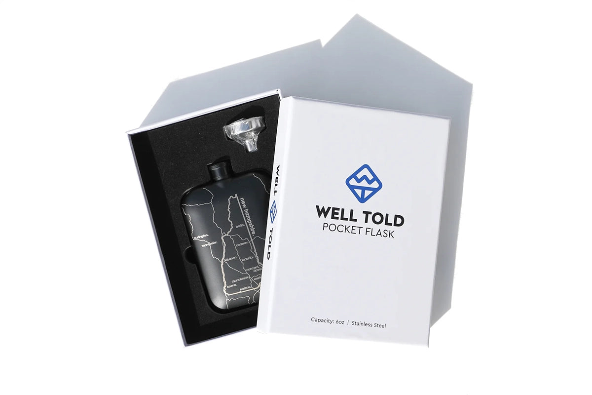 Well told brand Omaha flask in Black with stainless steel flask funnel, shown in packaging box