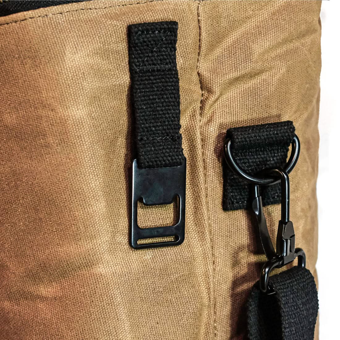 Close-up of the built-in bottle opener on the side hardware of the waxed canvas cooler bag, The Simple Man