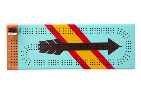 Top view of the West Cribbage Board featuring bold arrow artwork, full scoring layout, and bundled cribbage pegs.