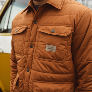 Close up of the Windward puffer jacket snap chest pocket and woven label, detail view