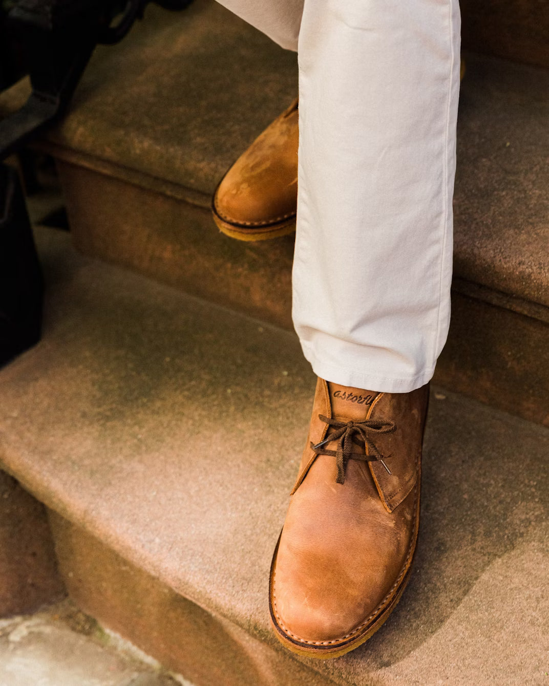 Pair of Astorflex Greenflex boots in dark chestnut nubuck side by side on wood surface – Italian-made sustainable men’s footwear