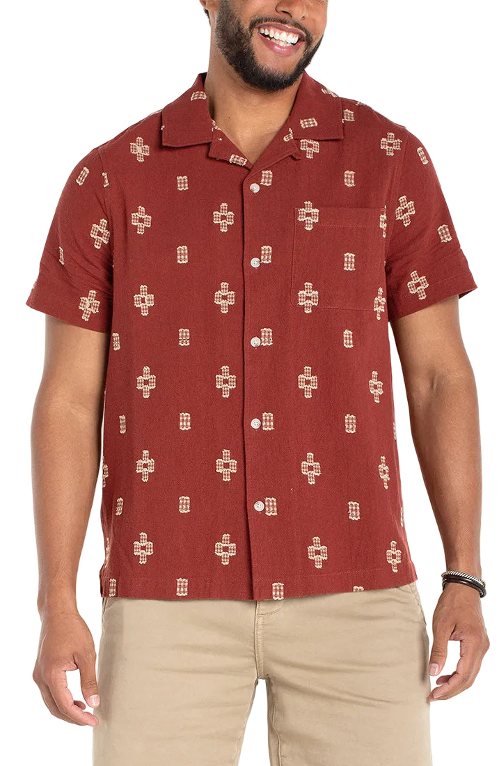 Men's cotton jacquard camp shirt in red – front view on model showing camp collar, button front, and woven cross motif pattern