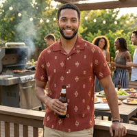 Man wearing men's red cotton jacquard camp shirt at outdoor backyard gathering – relaxed fit short sleeve button down with woven pattern