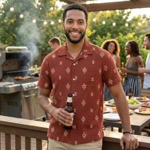 Man wearing men's red cotton jacquard camp shirt at outdoor backyard gathering – relaxed fit short sleeve button down with woven pattern