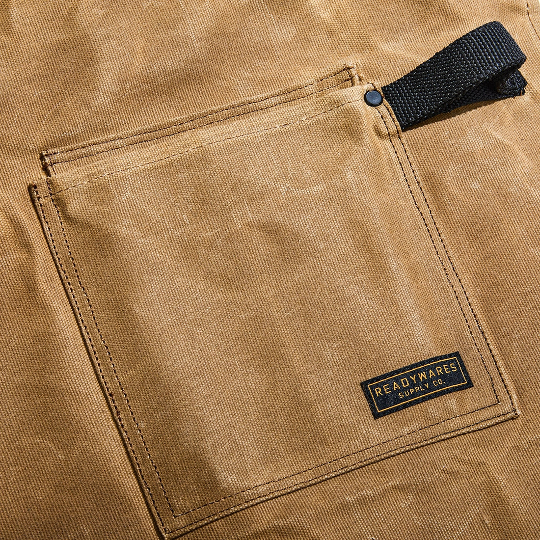 Readywares Supply Co. Deluxe Utility Apron pocket close-up — sawdust flap pocket with tool loop and Readywares label detail