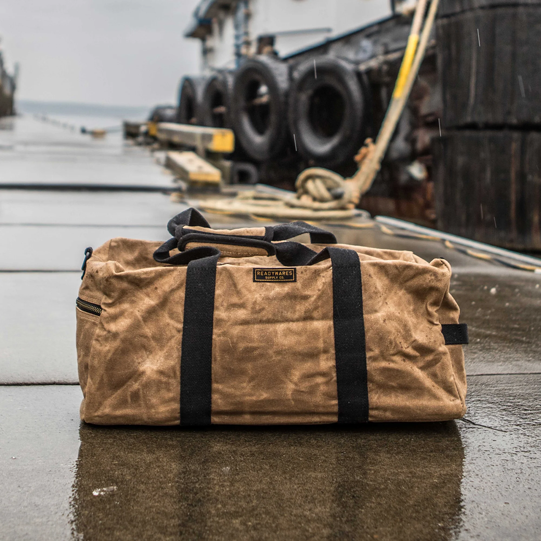 Readywares Waxed Canvas Duffel Bag, lifestyle shot on a rainy dock