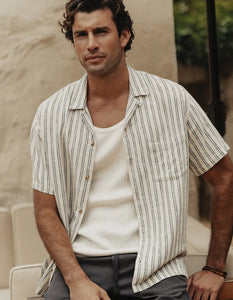 The Normal Brand Freshwater Resort Shirt Vintage Blue Stripe – lifestyle front view on model wearing men's linen camp shirt open over white tee