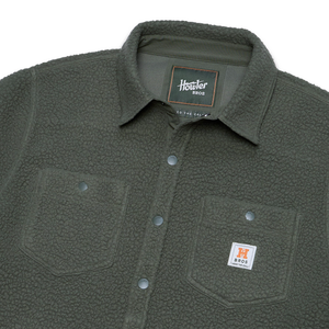 Close up of fleece overshirt collar, snaps and chest pocket label in Beetle