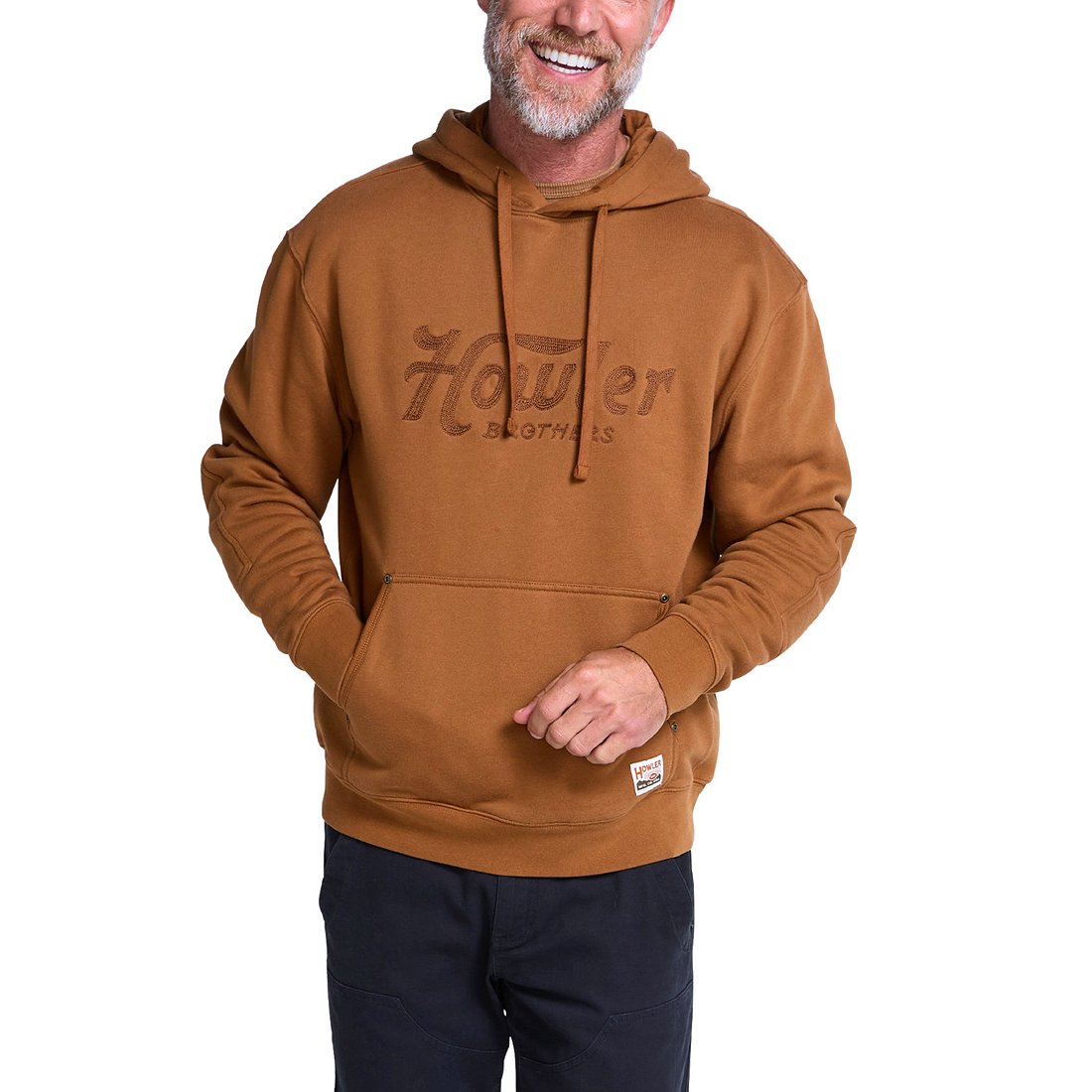 Man wearing Workbench tan hoodie with tone on tone Howler Script chest embroidery, front view