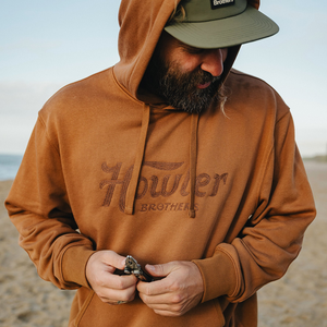 Man in Workbench Trade hoodie and cap on the beach