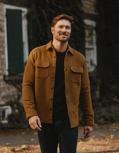 Man wearing The Normal Brand Heavyweight Chamois Overshirt in gold outside on a fall day, styled casually with dark jeans — men’s outerwear from The Simple Man.