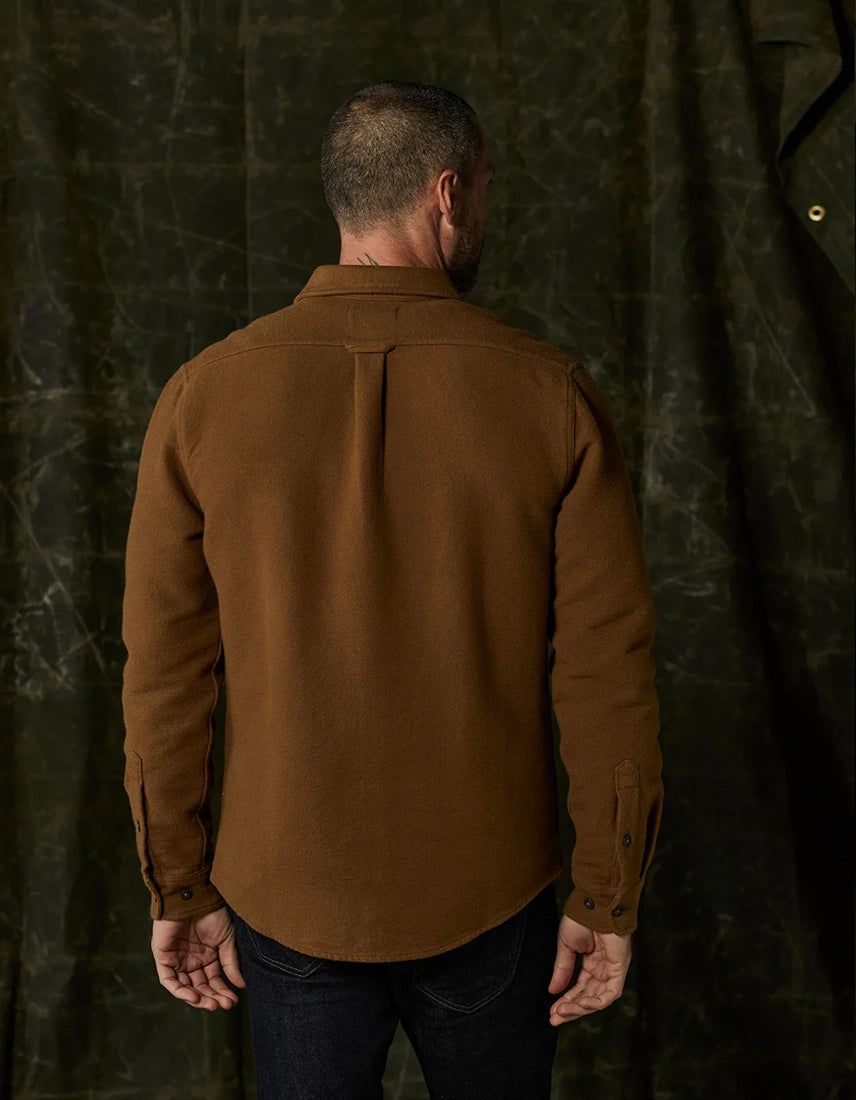 Man wearing The Normal Brand Heavyweight Chamois Overshirt in gold, back view showing box pleat and tailored fit — available at The Simple Man, Omaha.