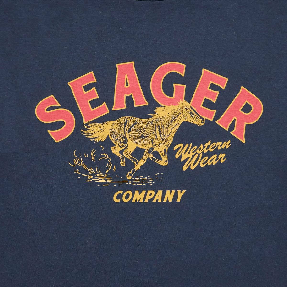 Close-up of Seager Western Wear logo with horse graphic on navy Heritage Tee