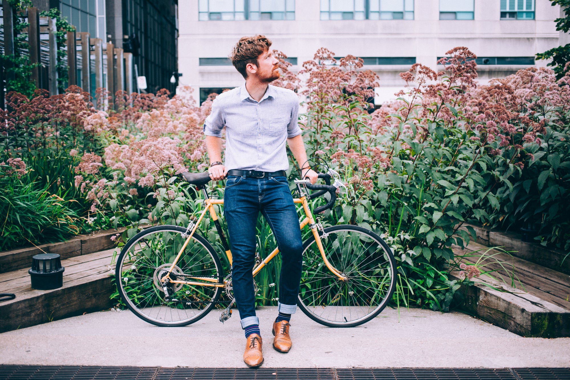 Men's Clothing,well dressed man leaning on a bicycle in front of flowers