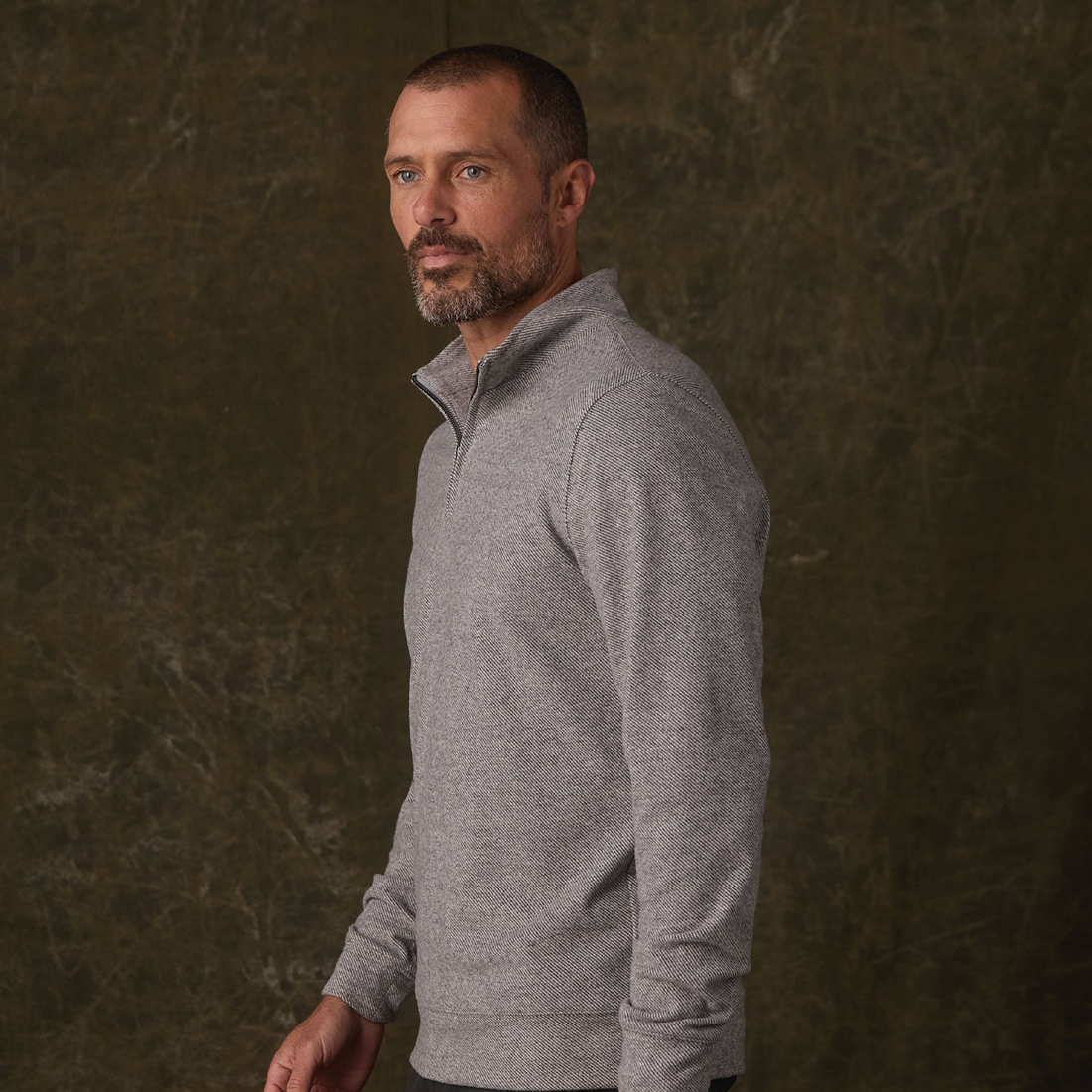 Side view of Graphite textured knit quarterzip on a man showing stand collar and cuffed sleeve