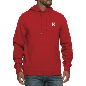 Man wearing a Nebraska Cornhuskers red hooded sweatshirt with a white N on the left chest and jeans