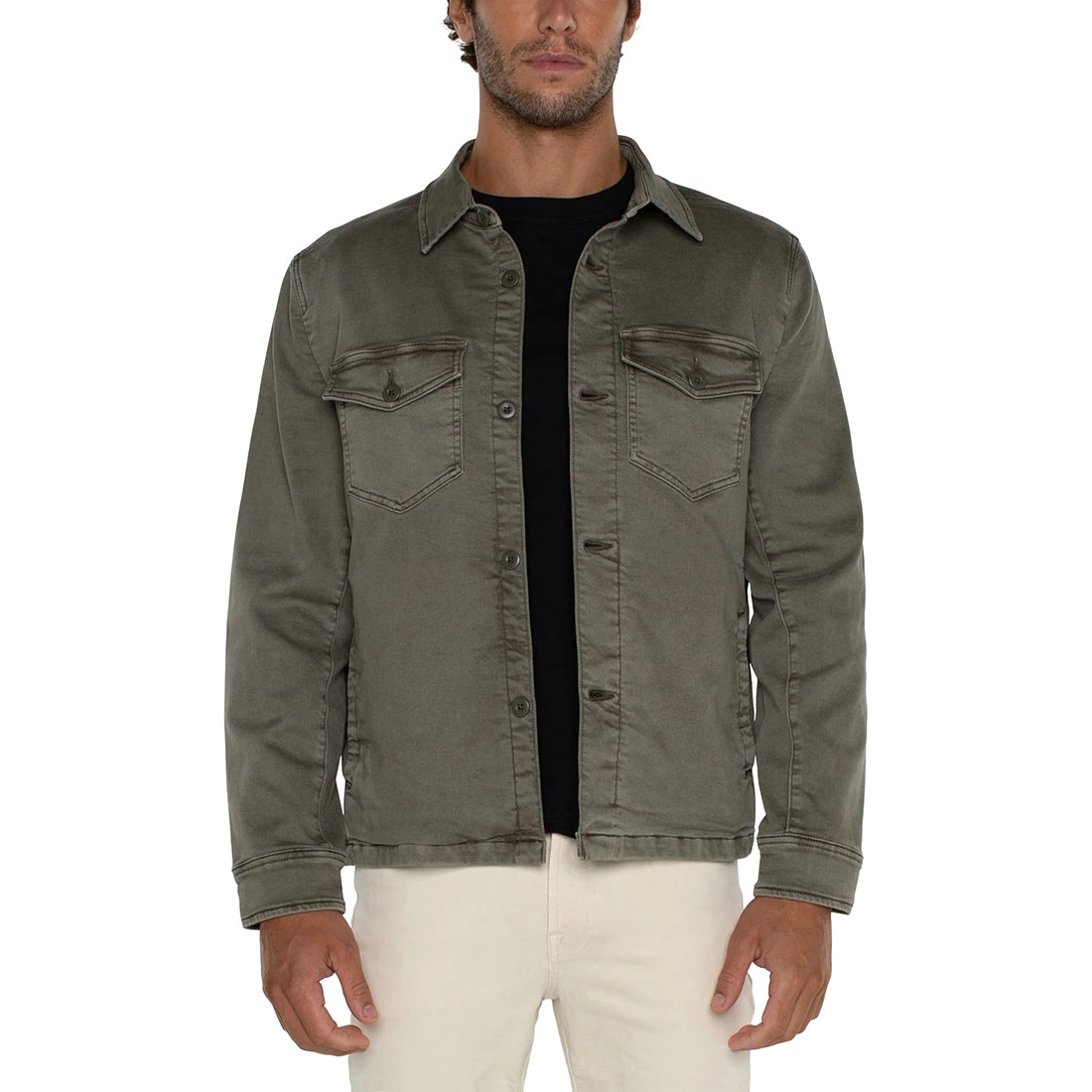 Man wearing a green denim jacket over a black shirt on a white background