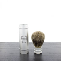 Parker pure badger travel shave brush shown next to its brushed aluminum ventilated tube on a black tabletop.