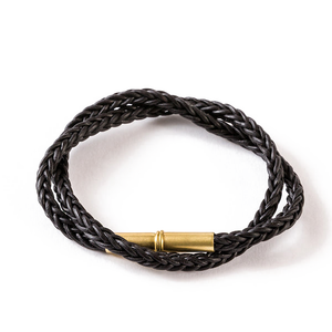 Black braided leather Flint bracelet with a brass .22 shell magnetic closure, double wrap, on a white background