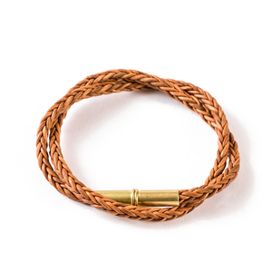 Natural tan braided leather Flint bracelet with a brass .22 shell magnetic closure, double wrap, on a white background