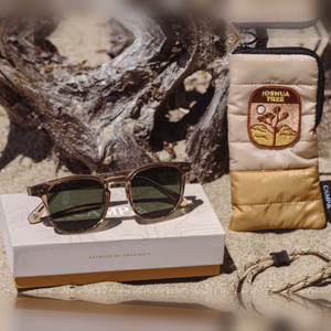 Topo Joshua Tree Edition sunglasses on a driftwood log next to the Joshua Tree pouch