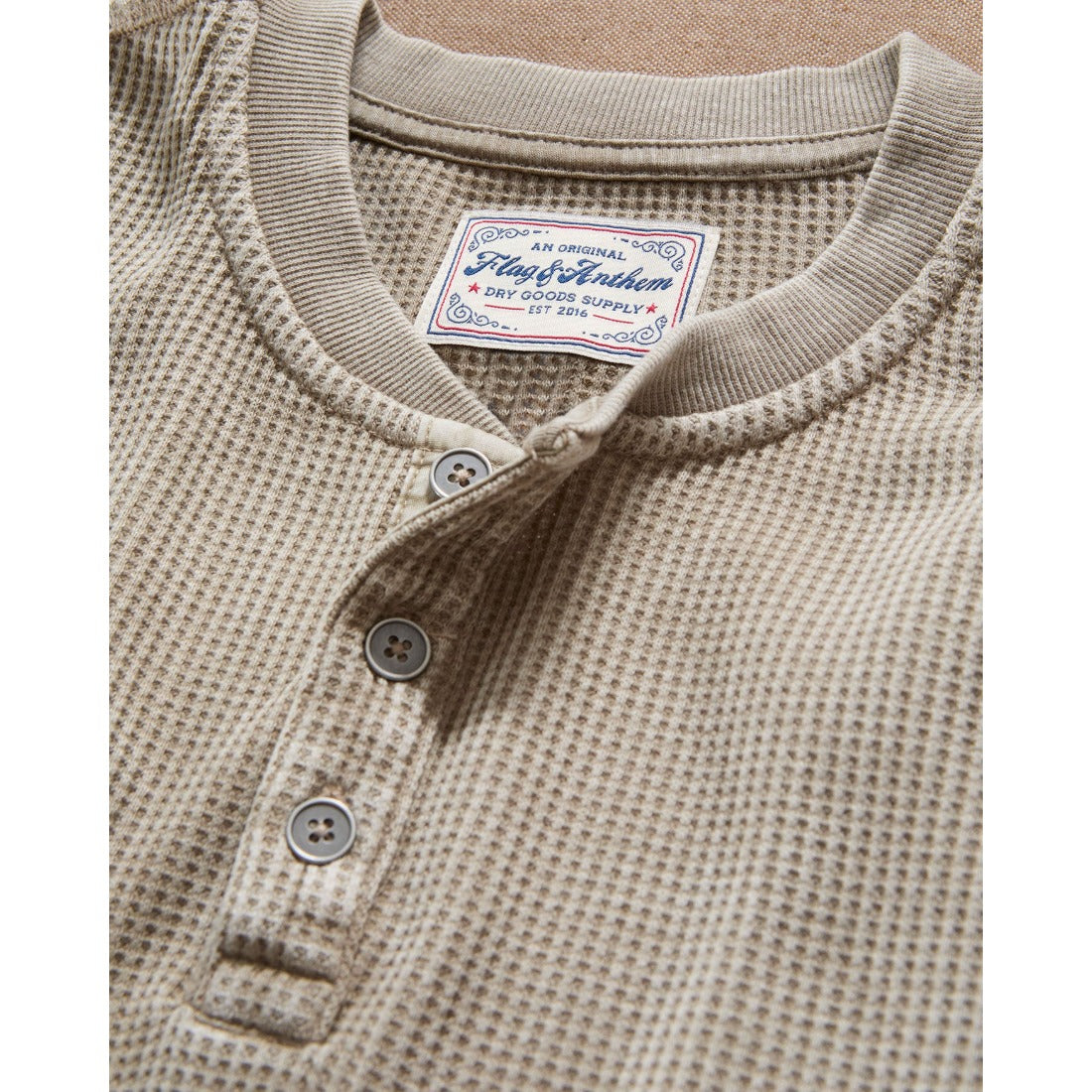 Close-up of the tan waffle henley three-button placket and textured knit